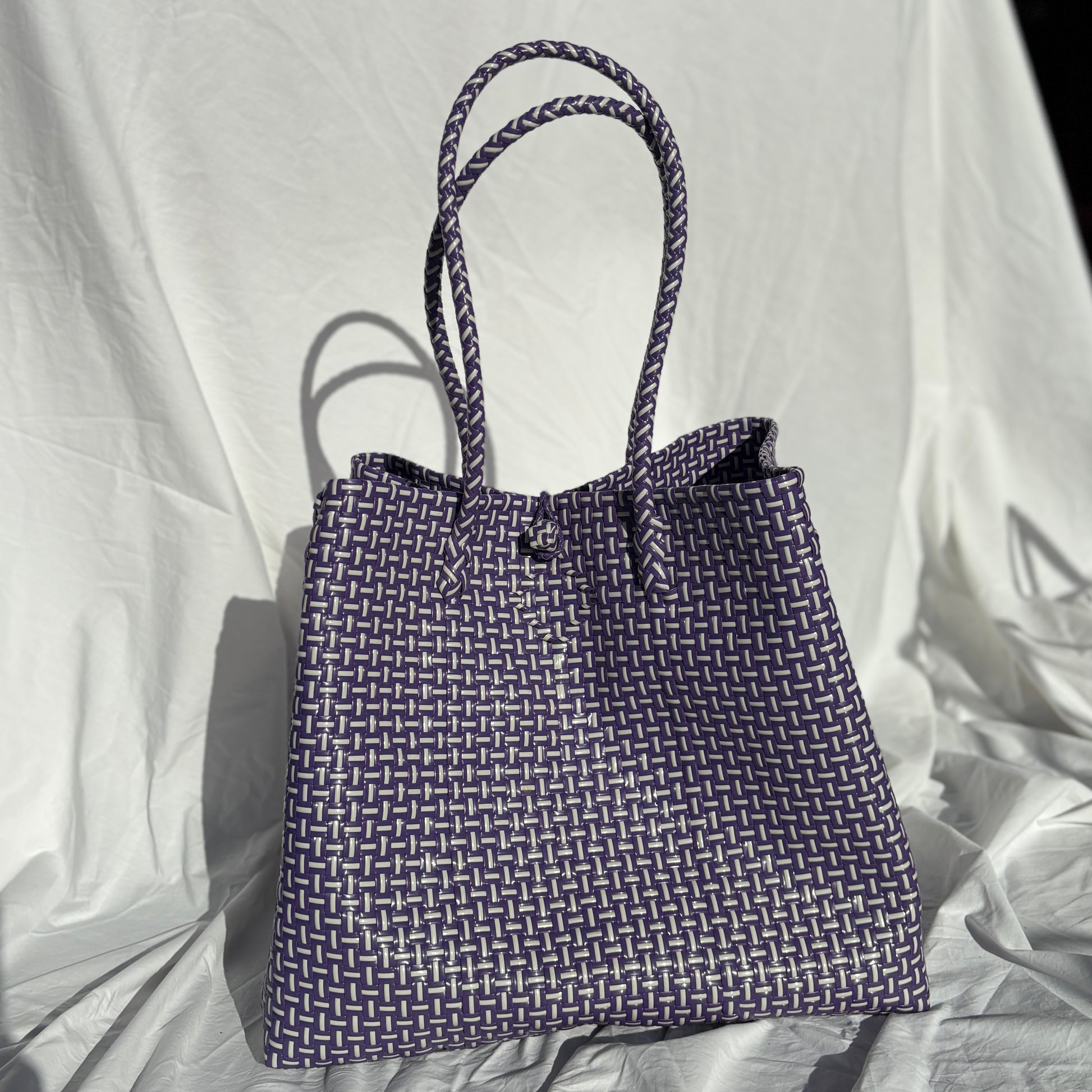 Blue woven tote bag on a white fabric background