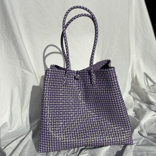 Blue woven tote bag on a white fabric background